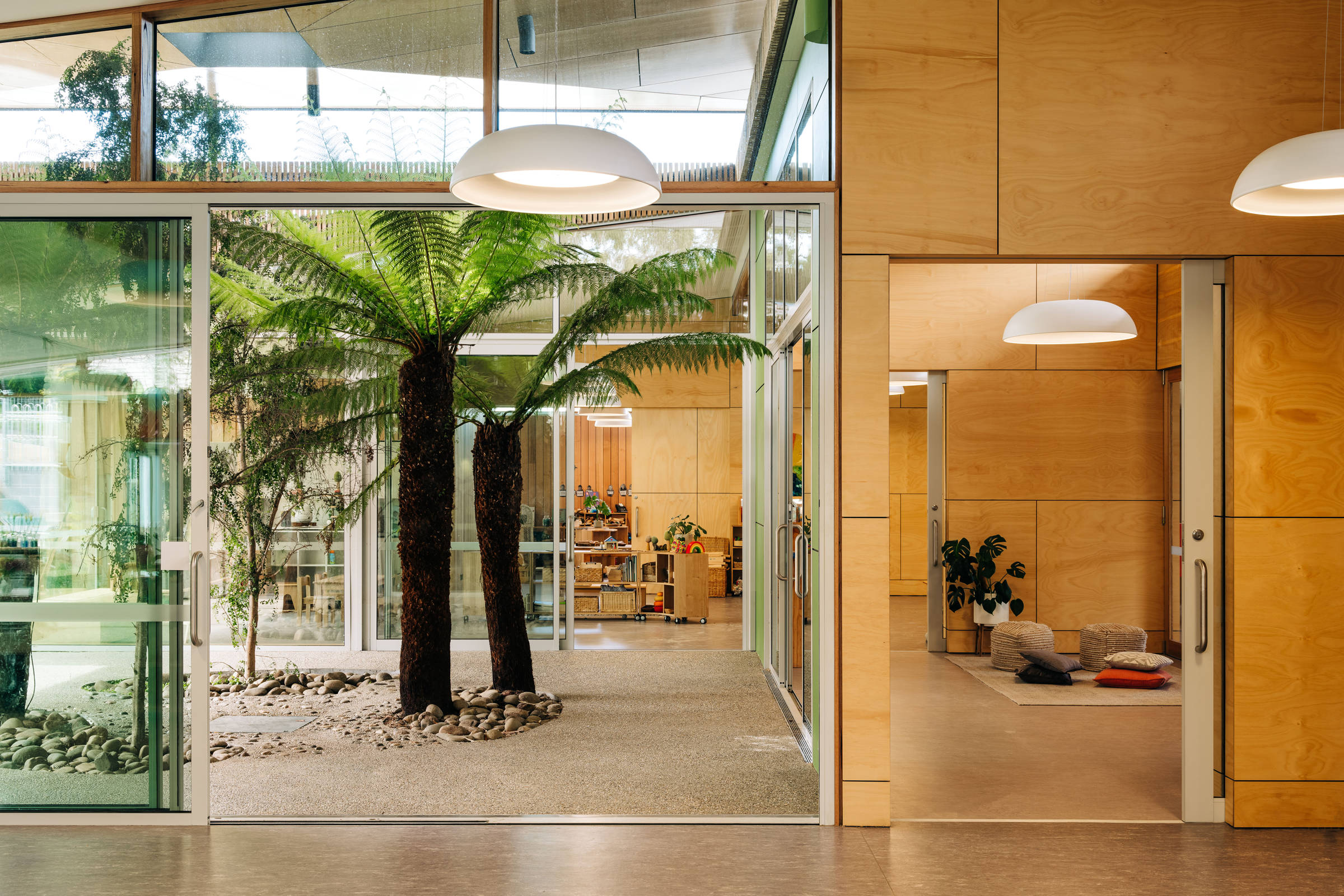 St Cuthbert’s Early Years – Catholic Education Tasmania: The covered rainforest atrium forms the building heart with layered interior learning spaces opening and extending into it. Photo by Adam Gibson. Photo by Adam Gibson.