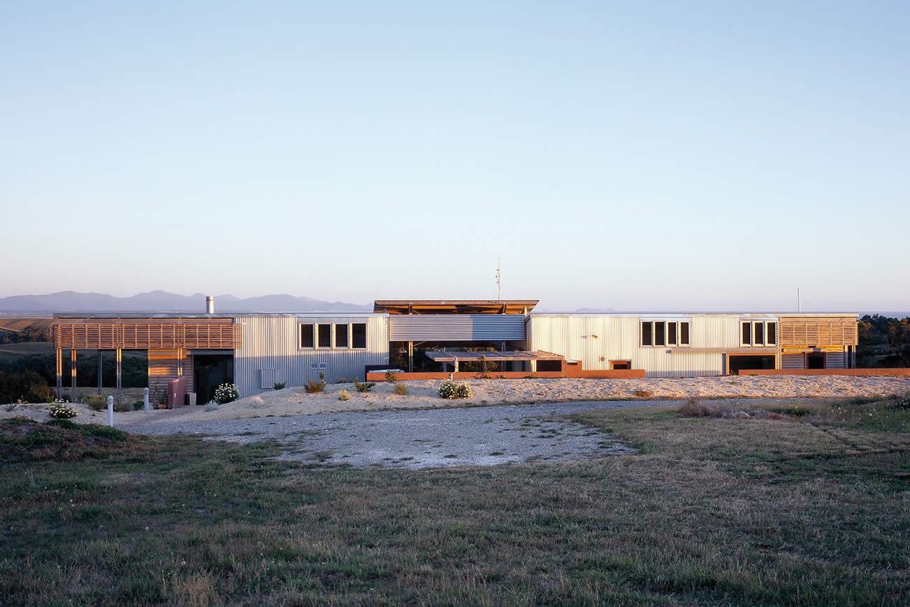 House Byrne, South Gippsland, Victoria: The horizontal building is partially sunken to reduce its scale and emphasise its physical link to the immediate landscape and its visual link to the mountains beyond. Photo by Richard Gange.